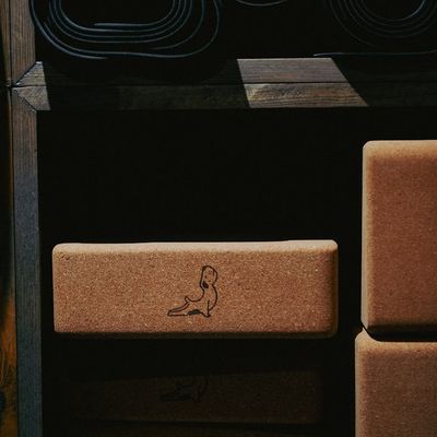 Yoga block and strap on a dark textured mat.